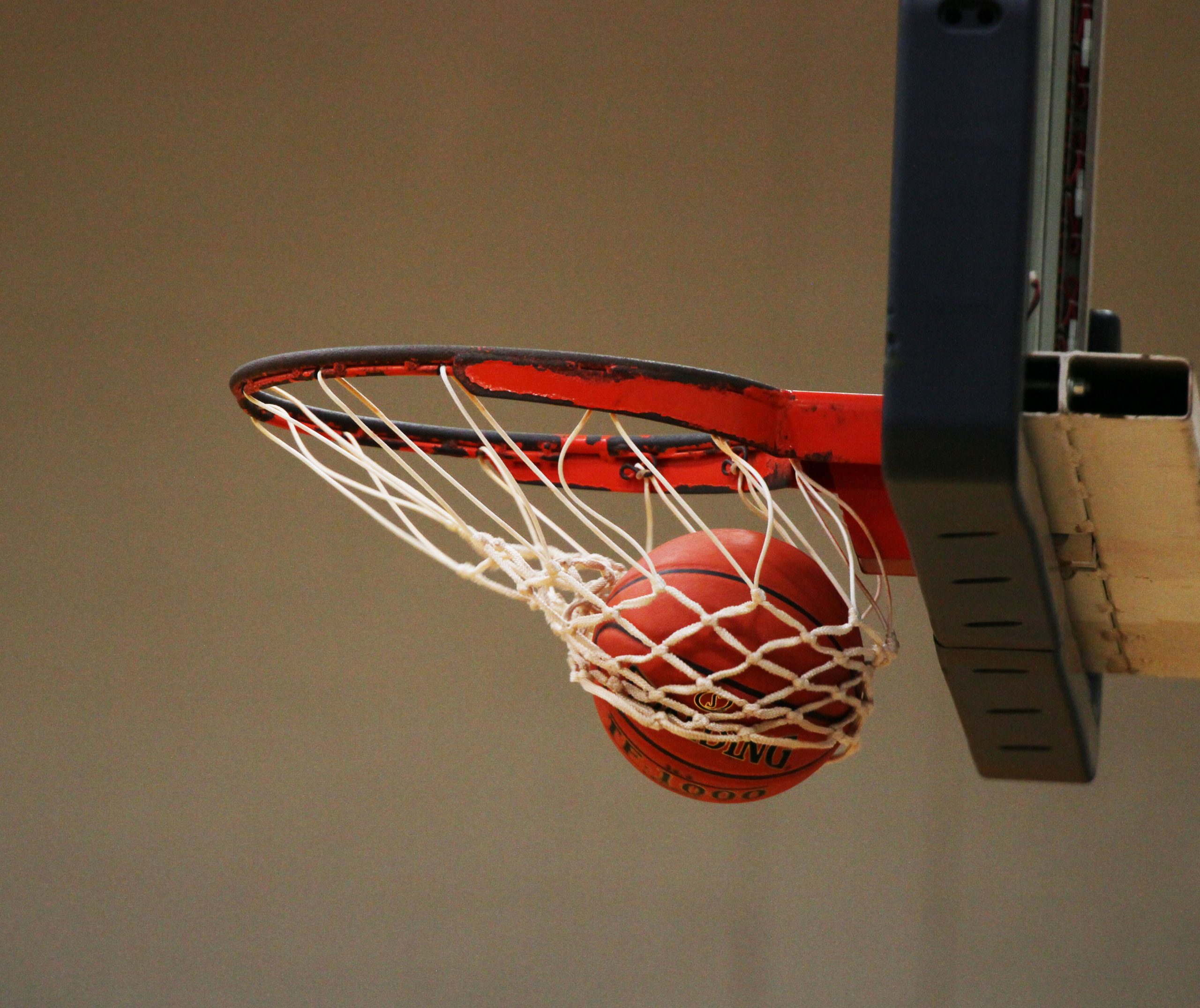 A basketball swooshing through a hoop.