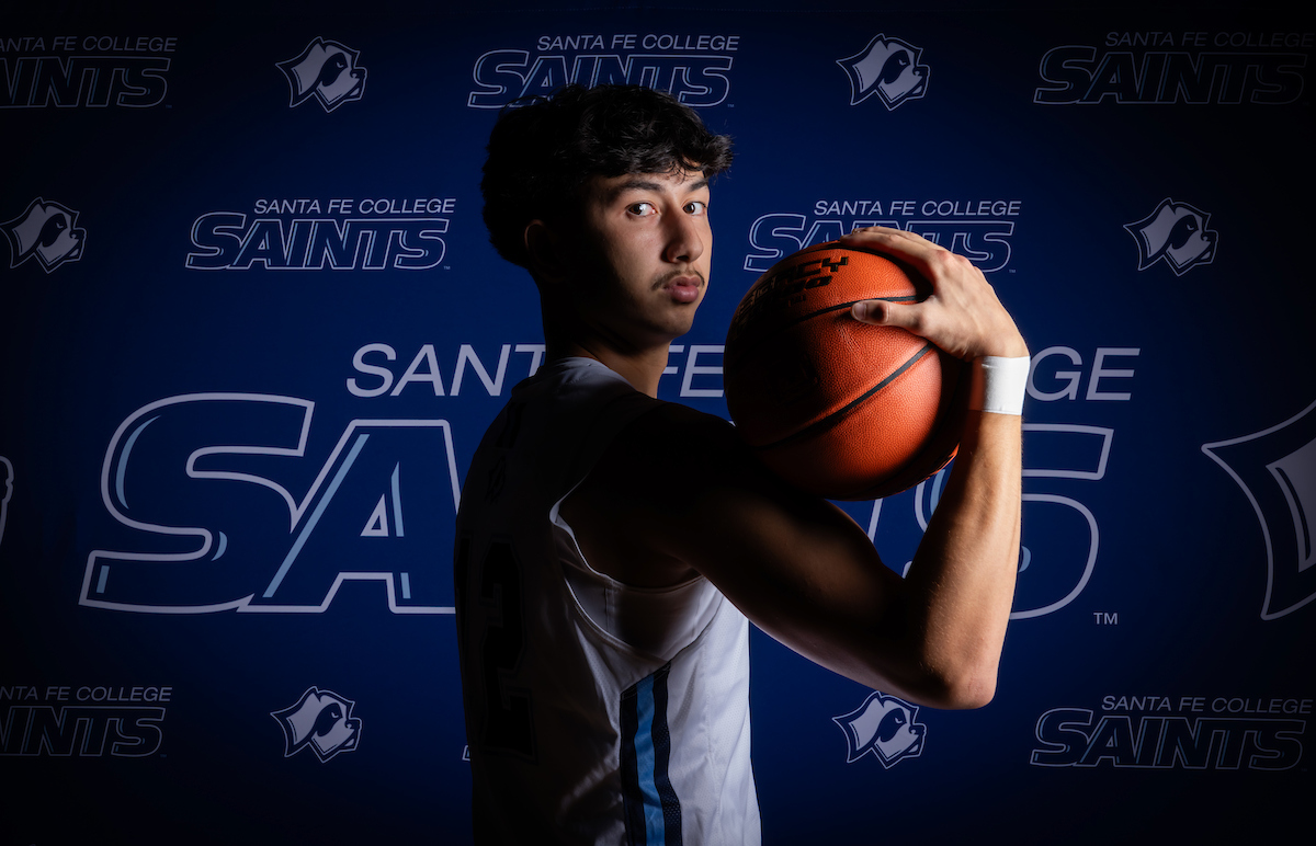 Santa Fe College Saints Men’s Basketball player Connor Morris holding a basketball on his shoulder.