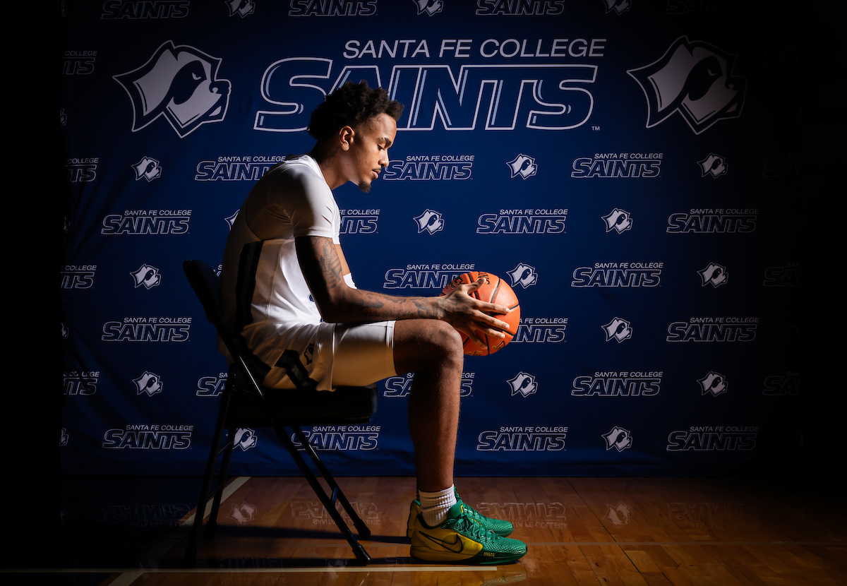  Santa Fe College Saints Men's Basketball player Karmello Branch gazes at the basketball in his hands.