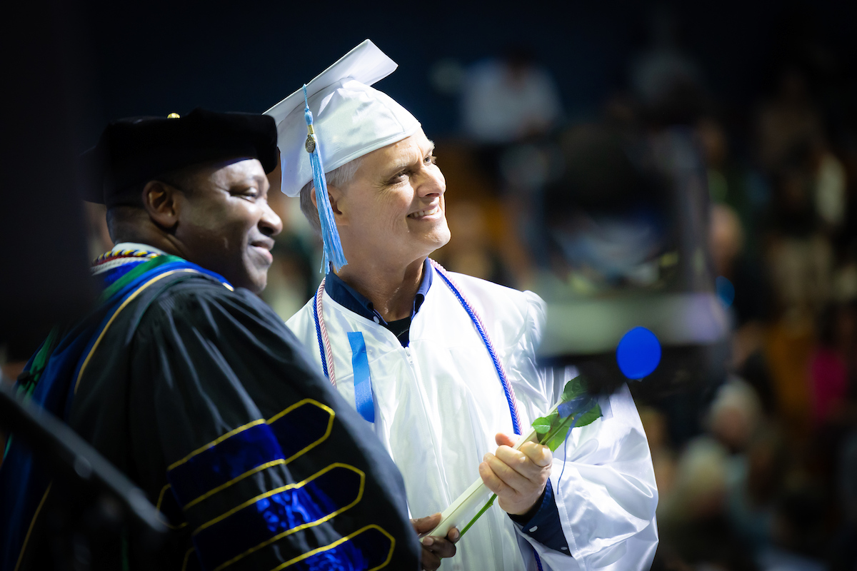 Santa Fe College President Paul Broadie with a nursing graduate during the Fall 2024 pinning ceremony.