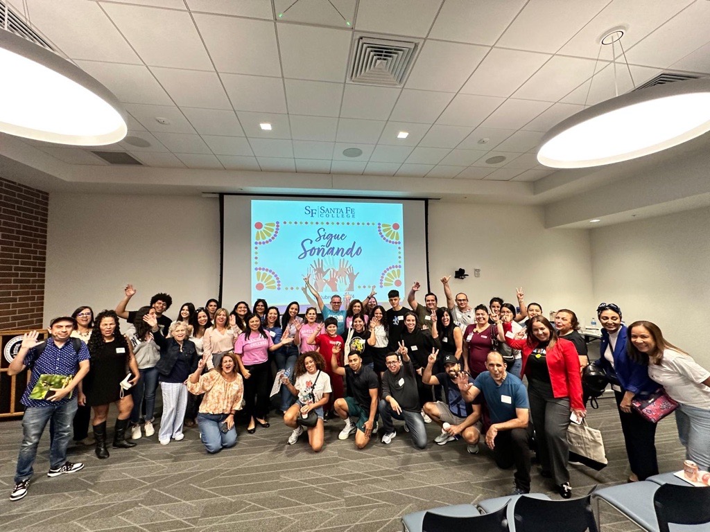 A crowd of individuals pose for a photo at Santa Fe College's Sigue Sonañdo event.