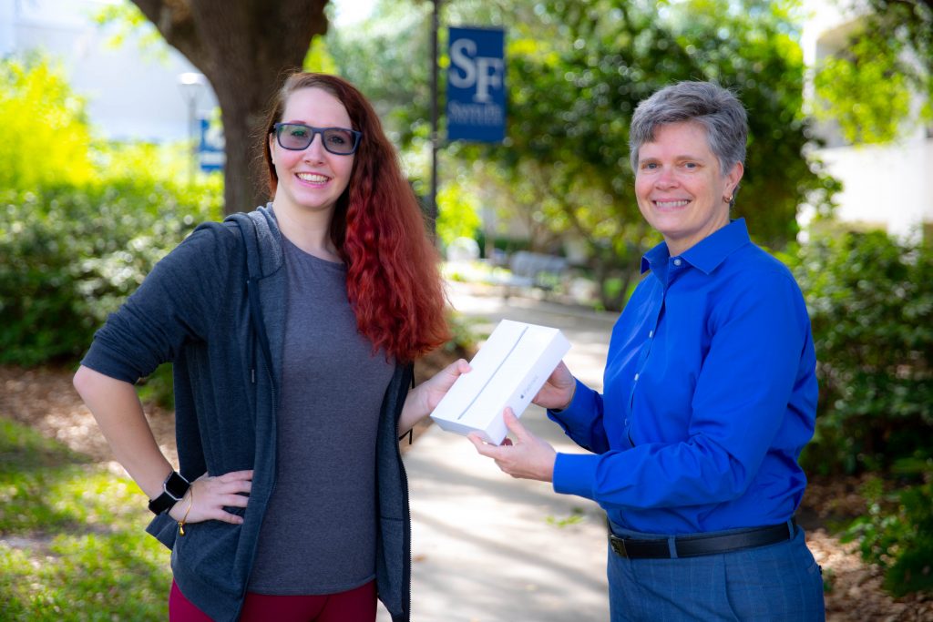 Cheryl Calhoun, PhD, Dean of Access and Inclusion, presents Megan Bossert with an iPad Mini on April 8, 2019 in Gainesville, Fla. Bossert won the iPad for completing the National Assessment of Collegiate Campus Climate (NACCC) survey.