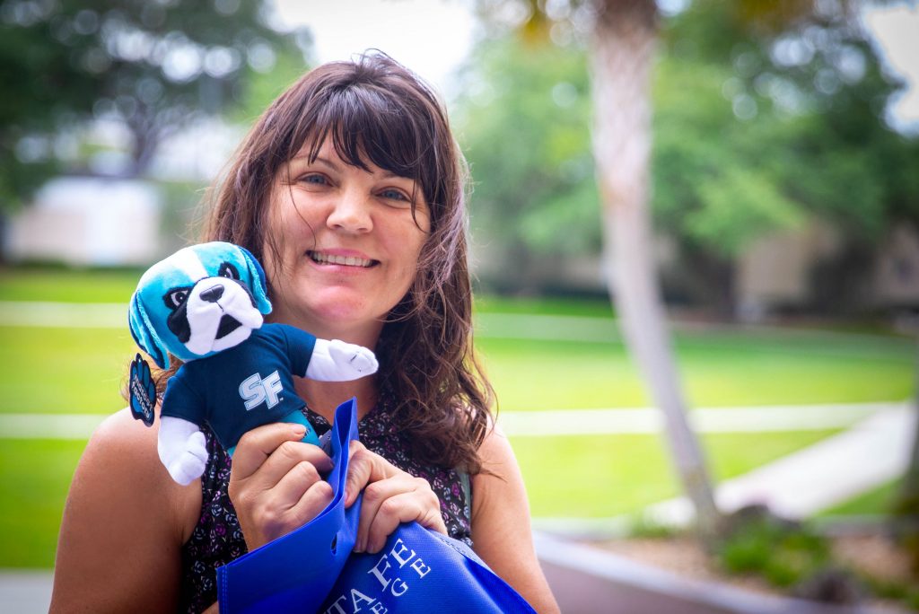 Sarah Cervone, SF Brand Ambassador for April 2019, holding a plush Caesar mascot.