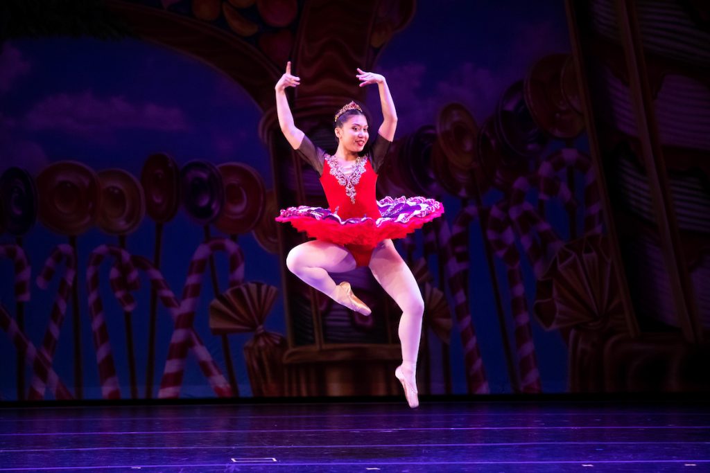 Ballerina dancing and jumping in the air during a performance.