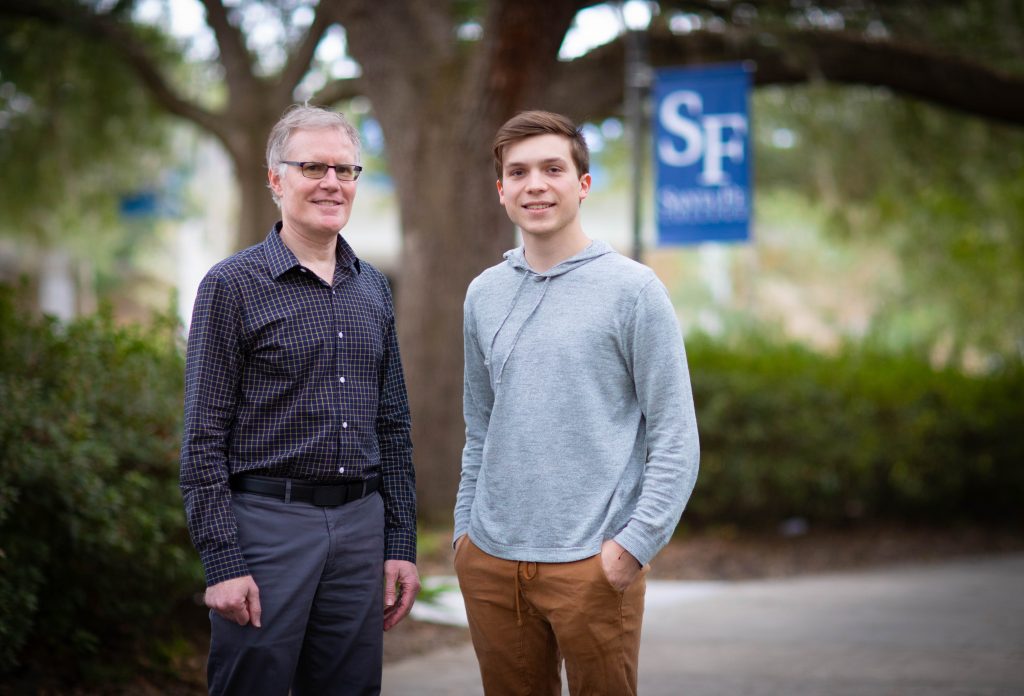 Man in black shirt standing next to man in grey 