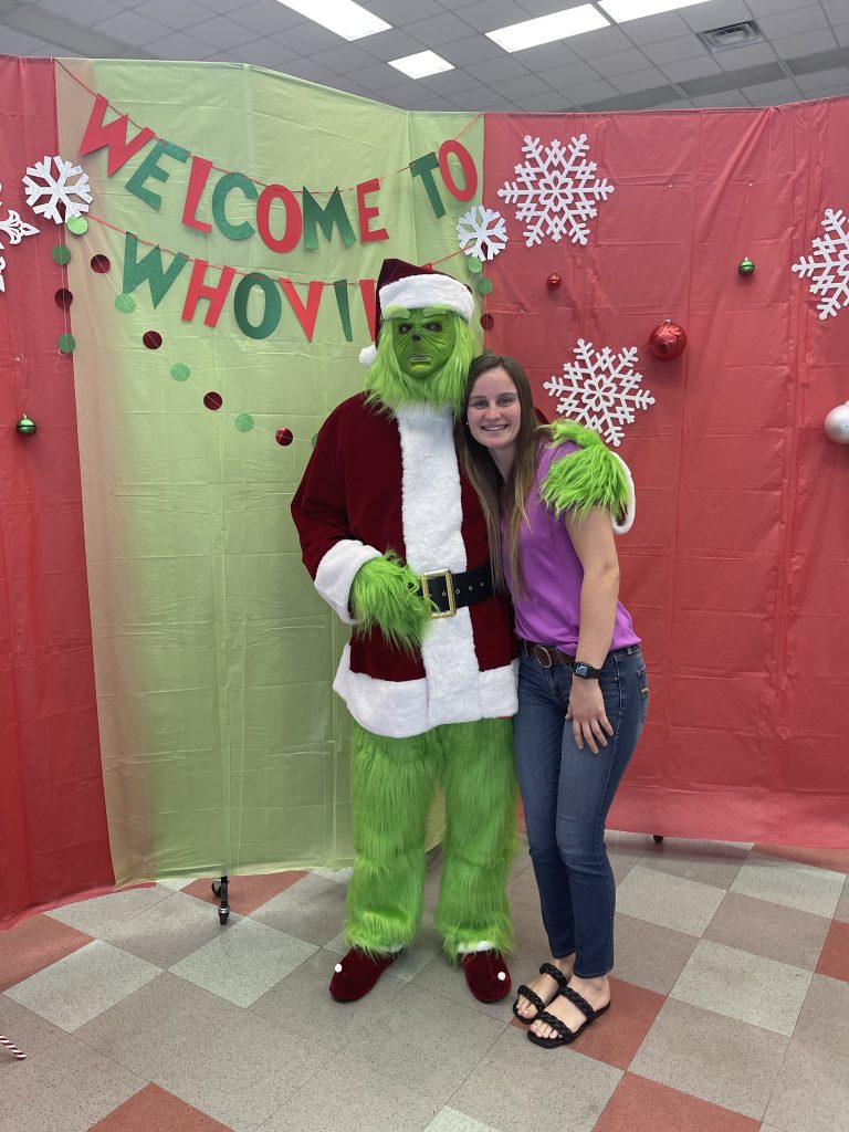 Santa Fe College employees posing with the Grinch at a holiday party event.