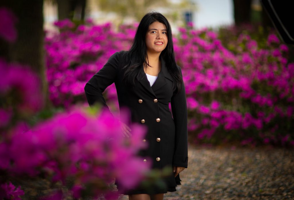 Marcela Murillo standing amid flowers