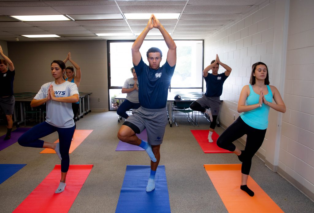 seven people doing yoga in a room