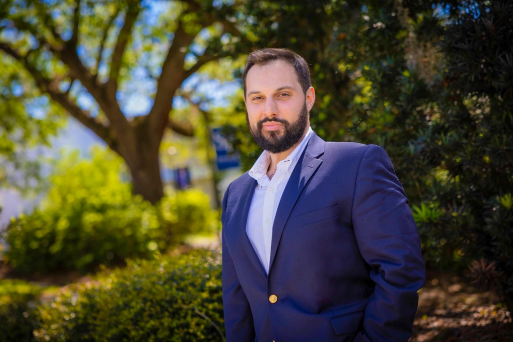 James Fortuna standing amid a tree and shrubs