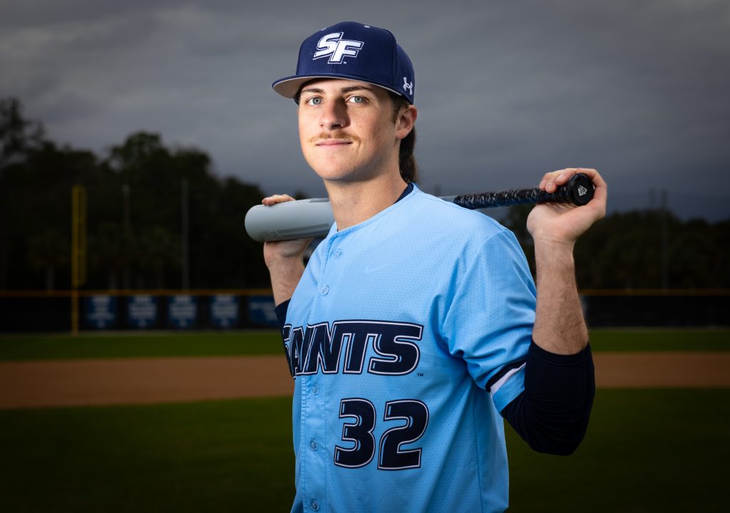 Santa Fe College saints Baseball player Anthony Fimiano holds a baseball bat across his shoulders.