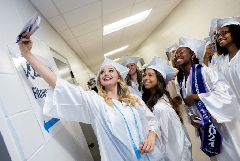 SF Nursing graduates pose for a selfie inside SF's gym.